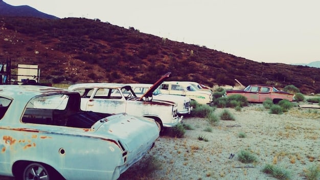 A wide angle shot capturing multiple vintage Cadillacs half-buried in the ground at Cadillac Ranch, covered in layers of colorful graffiti against a stark blue sky. Tourists are seen spray-painting the vehicles.