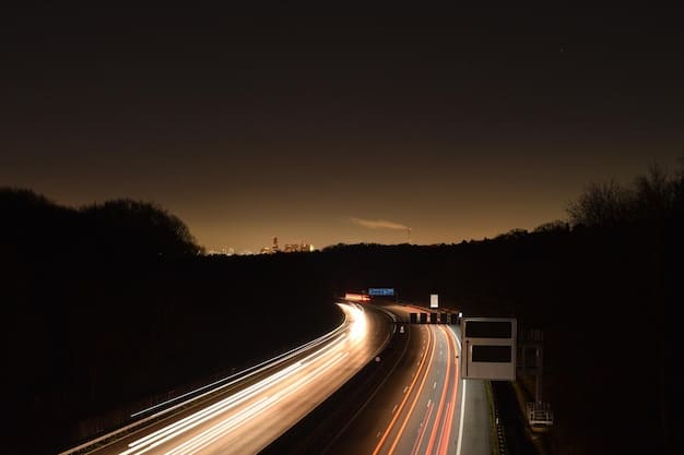 A long exposure shot of a highway at dusk showing a mix of semi trucks, electric vehicles and a freight train in the distance, all transporting goods, symbolizing the different modes of transporting goods in response to rising energy costs.