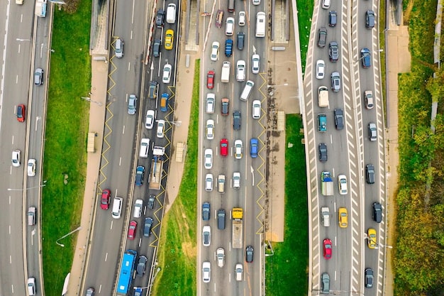 An aerial view of a busy highway during daytime. Cars are moving in both directions, with brake lights illuminated on a few vehicles, indicating stopping or slowing down. The image conveys the potential danger associated with vehicle defects that can affect braking systems or safety features.
